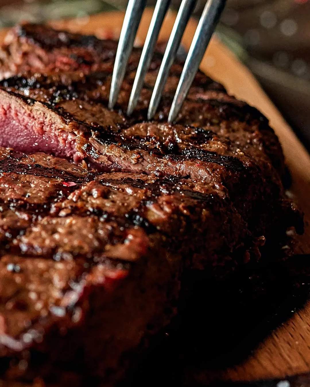 Close-up of charcoal-grilled medium-rare steak on wooden board at Hemdem Istanbul steakhouse