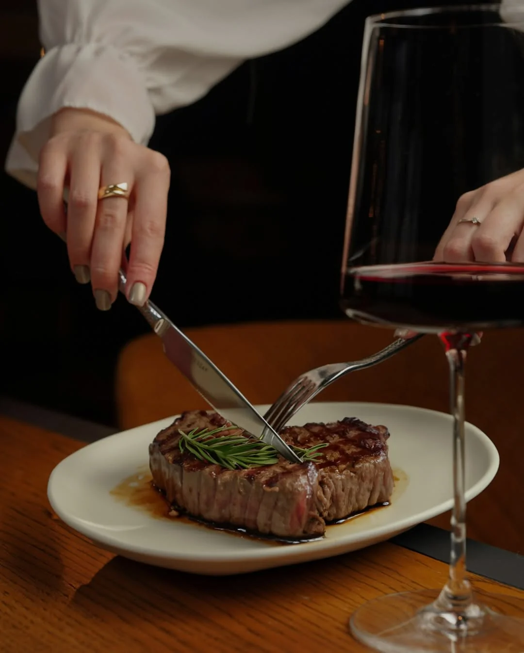 Filet mignon being carved at table with red wine glass alongside, Hemdem Istanbul steakhouse